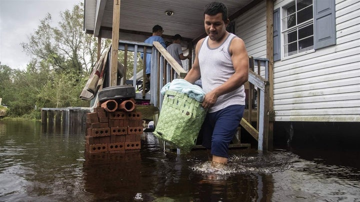 A man helps his family move out of their flooded home in Kinston, North Carolina. Hurricane Florence flooded the Neuse River 