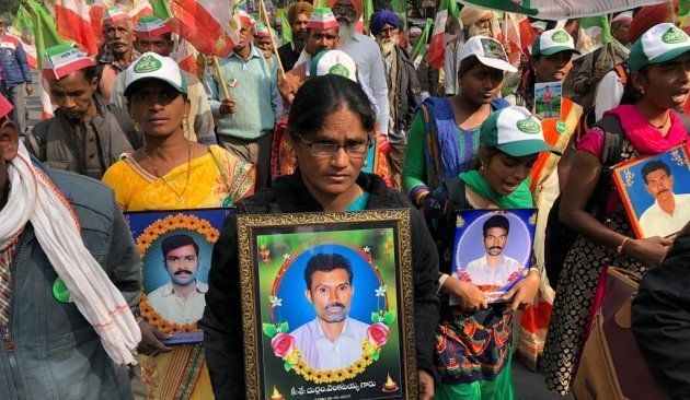 Women march with the photos of relatives who killed themselves because of the agrarian crisis.