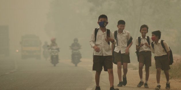 Students walk along a street as they are released from school to return home earlier due to the haze in Jambi, Indonesia's Jambi province, September 29, 2015 in this file picture taken by Antara Foto. Antara Foto/Wahdi Setiawan/via REUTERS/File Photo ATTENTION EDITORS - THIS IMAGE WAS PROVIDED BY A THIRD PARTY. FOR EDITORIAL USE ONLY. MANDATORY CREDIT. INDONESIA OUT.