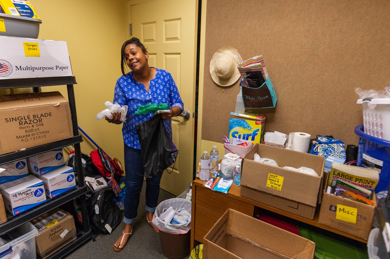 Briana Martin, drop-in center manager at Covenant House, shows the bags of hygienic products that are handed out to at-risk populations in Charleston. The green bag is for people to use to clean up their own waste.