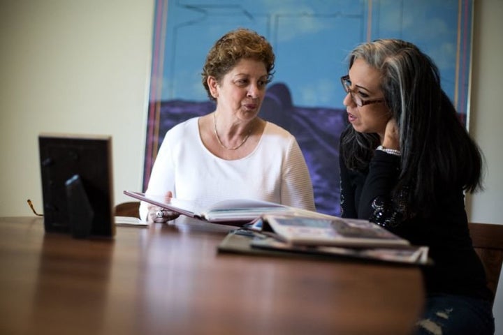 Judy Matt (left) and Gina Aparicio look at family albums together in Judy’s living room, on June 24, 2018, in Providenc