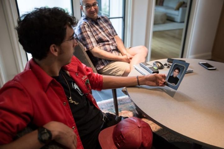 Michael Matt (left) looks at a photo of himself as a child that his father, Andrew Matt, has brought out to show him, on June 24, 2018, in Providence, Rhode Island.