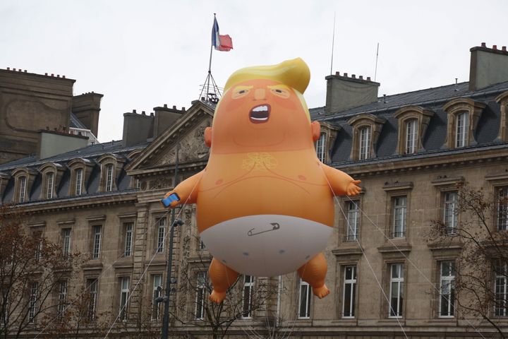 A balloon Trump wearing a diaper flies overhead as people protest at the Place de la Republique in central Paris on Nov. 11, 2018.