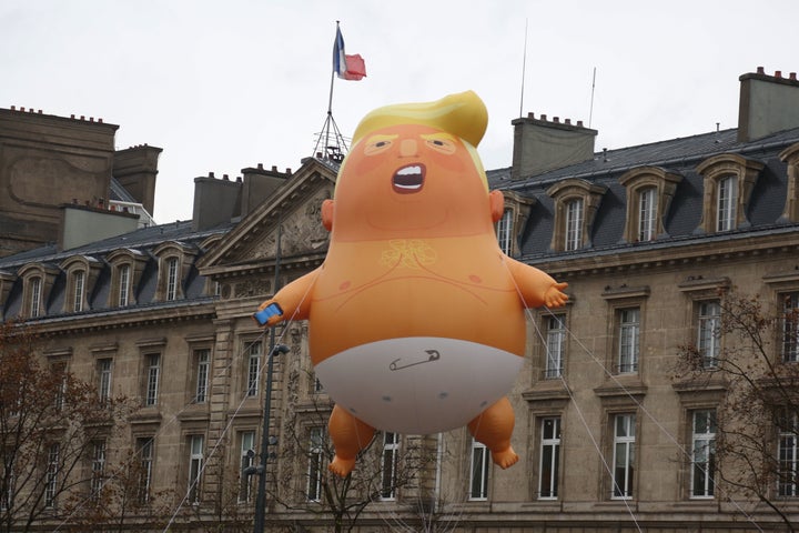 A balloon Trump wearing a diaper flies overhead as people protest at the Place de la Republique in central Paris on Nov. 11,