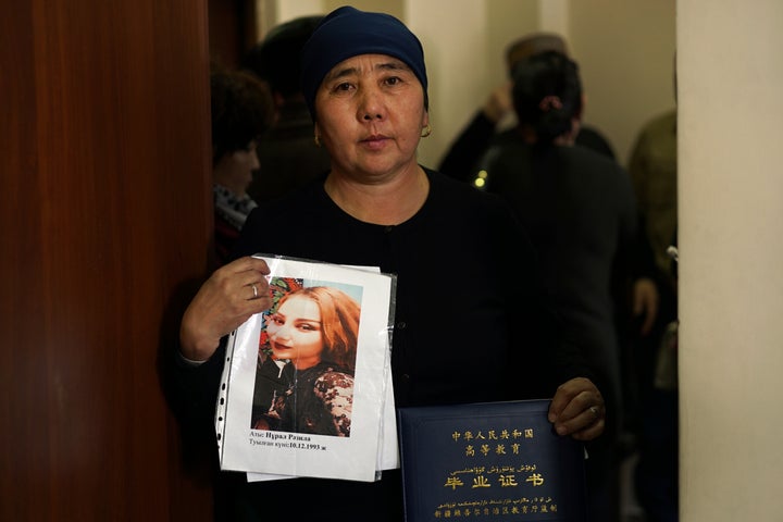 In this Dec. 6, 2018, photo, Nurbakyt Kaliaskar, the wife of a sheep herder, holds up a picture of her daughter, Rezila Nulale, and her graduation certificate, at an office of an advocacy group for ethnic Kazakhs born in China in Almaty, Kazakhstan on December 6, 2018. Kaliaskar says her daughter, a college graduate who had a job in advertising, was detained in an internment camp in China's far western region of Xinjiang and is now being forced to make clothes for no pay.