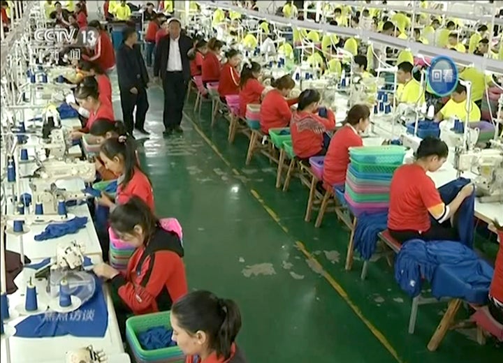 In this file image from undated video footage run by China's CCTV, Muslim trainees work in a garment factory at the Hotan Voc