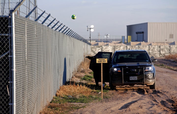 A private security guard throws a soccer ball back inside the Tornillo detention camp for migrant teens in Tornillo, Texas.&n