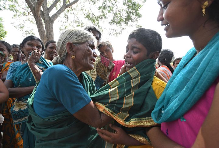 A boy cries consoled by his grandmother after his mother died of suspected food poisoning at Bidarahalli, near Sulawadi village in Chamarajnagar district of Karnataka, Dec. 15, 2018. 
