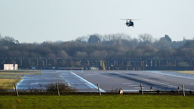 A helicopter conducts searches above Gatwick's runway on Thursday morning.