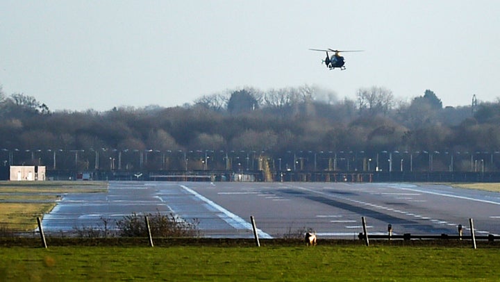 A helicopter conducts searches above Gatwick's runway on Thursday morning.