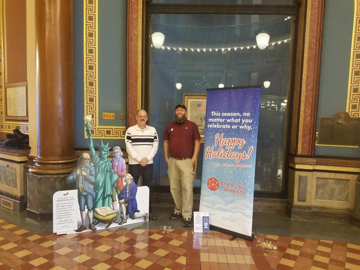 A holiday banner from the <a href="https://www.radioiowa.com/2018/12/12/atheist-holiday-banner-hanging-for-first-time-in-iowa-state-capitol/" role="link" class=" js-entry-link cet-external-link" data-vars-item-name="American Atheists" data-vars-item-type="text" data-vars-unit-name="5c082e3ee4b069028dc6289e" data-vars-unit-type="buzz_body" data-vars-target-content-id="https://www.radioiowa.com/2018/12/12/atheist-holiday-banner-hanging-for-first-time-in-iowa-state-capitol/" data-vars-target-content-type="url" data-vars-type="web_external_link" data-vars-subunit-name="article_body" data-vars-subunit-type="component" data-vars-position-in-subunit="14">American Atheists</a> (right) stands next to an alternative nativity display from the <a href="https://ffrf.org/news/news-releases/item/28182-ffrf-nativity-display-debuts-at-iowa-capitol" target="_blank" role="link" class=" js-entry-link cet-external-link" data-vars-item-name="Freedom From Religion Foundation" data-vars-item-type="text" data-vars-unit-name="5c082e3ee4b069028dc6289e" data-vars-unit-type="buzz_body" data-vars-target-content-id="https://ffrf.org/news/news-releases/item/28182-ffrf-nativity-display-debuts-at-iowa-capitol" data-vars-target-content-type="url" data-vars-type="web_external_link" data-vars-subunit-name="article_body" data-vars-subunit-type="component" data-vars-position-in-subunit="15">Freedom From Religion Foundation</a> at the Iowa State Capitol building.