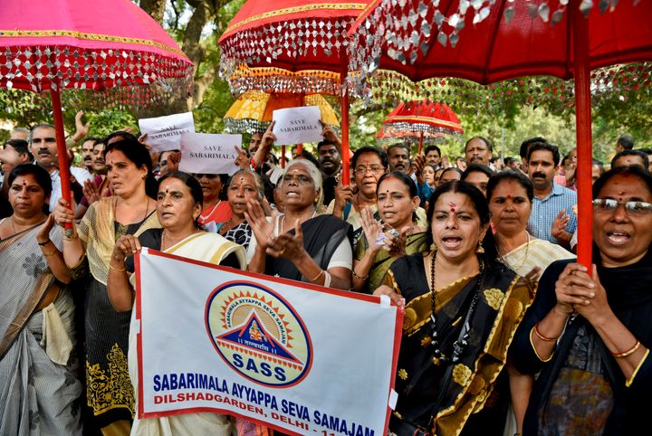 Women hold decorative umbrellas used for temple processions and chant religious hymns worshipping Lord Ayyappa, the deity of Sabarimala temple, as they arrive for a protest against a recent Supreme Court verdict in New Delhi, on 7 October 2018. 