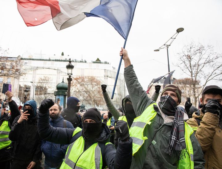 Protesters wearing yellow vests chant slogans and wave the French national flag during the anti-government demonstrations in Paris on Dec. 8, 2018.