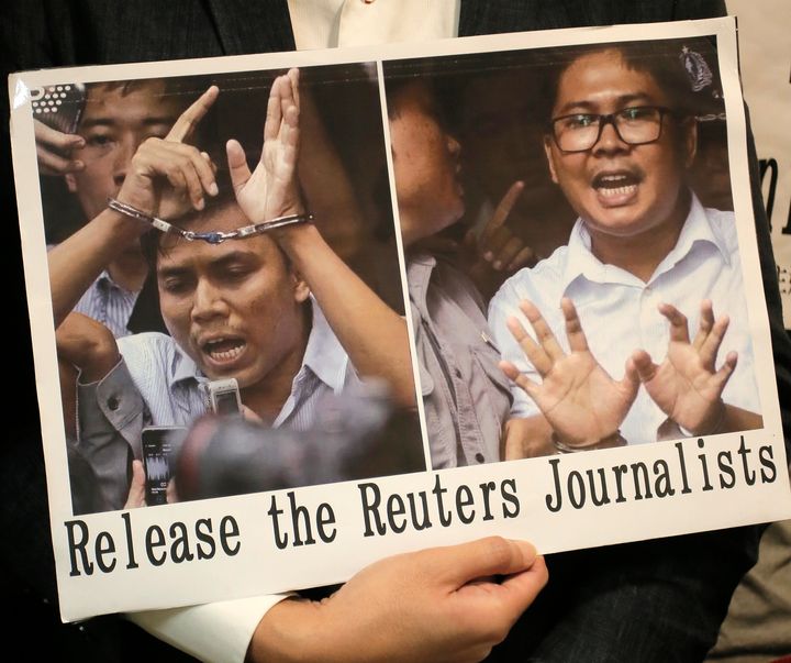 A protester holds a placard outside the Myanmar consulate in Hong Kong after a Myanmar court sentenced two Reuters journalists to seven years in prison.