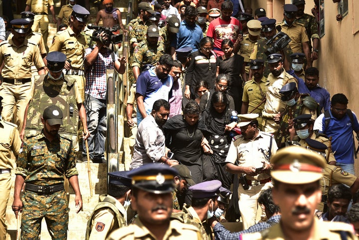 Cops escort women activist from a 'Manithi' NGO as they return back after being surrounded by Hindu activist to stop their attempt to reach Sabarimala Ayyapa temple, in Pamba in Kerala, on December 23, 2018. 