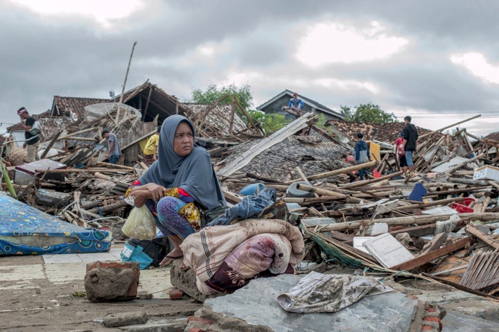 Everything is gone: A tsunami survivor sits on debris from her house in Sumur, Indonesia.