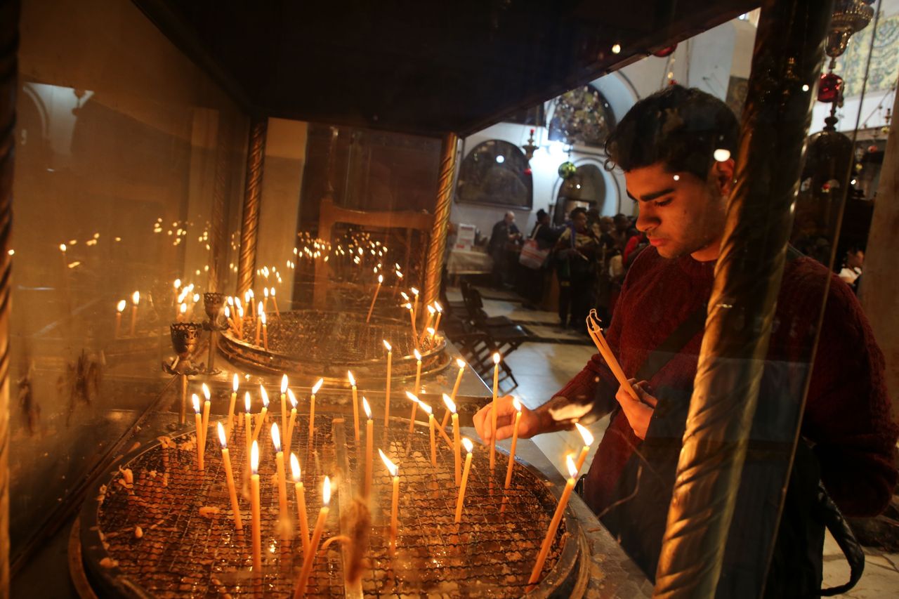 Προσκυνητές ανάβουν κερί στη Βασιλική της Γεννήσεως στη Βηθλεέμ
