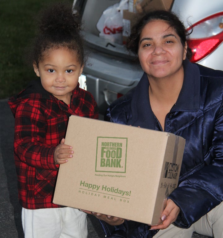 Veronica and her 2-year-old daughter receive a holiday meal box at Open Arms Mission Food Pantry in Antioch, Illinois, in 2016. The Northern Illinois Food Bank's meal boxes are packed with a turkey or ham, potatoes and other traditional holiday foods for a family of eight.