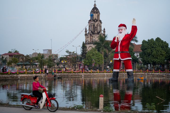 A giant, floating Santa Claus stands in a lake in front of Phu My Cathedral outside Hanoi, Vietnam. 