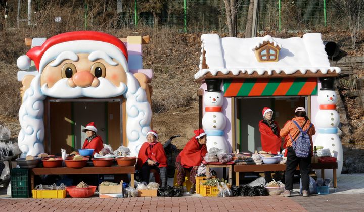 People wearing Santa Claus outfits to celebrate Christmas sell products at the Santa Village near the Buncheon Station Plaza in Bonghwa, South Korea.