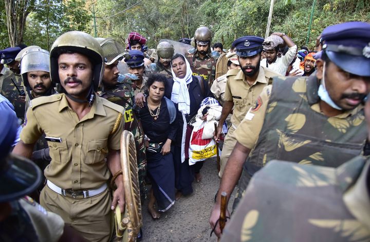 Police escort Kanaga Durga and Bindu after their group of women was stopped by protesters during an effort to reach the Sabarimala Ayyapa temple from Pamba in Kerala on 24 December.
