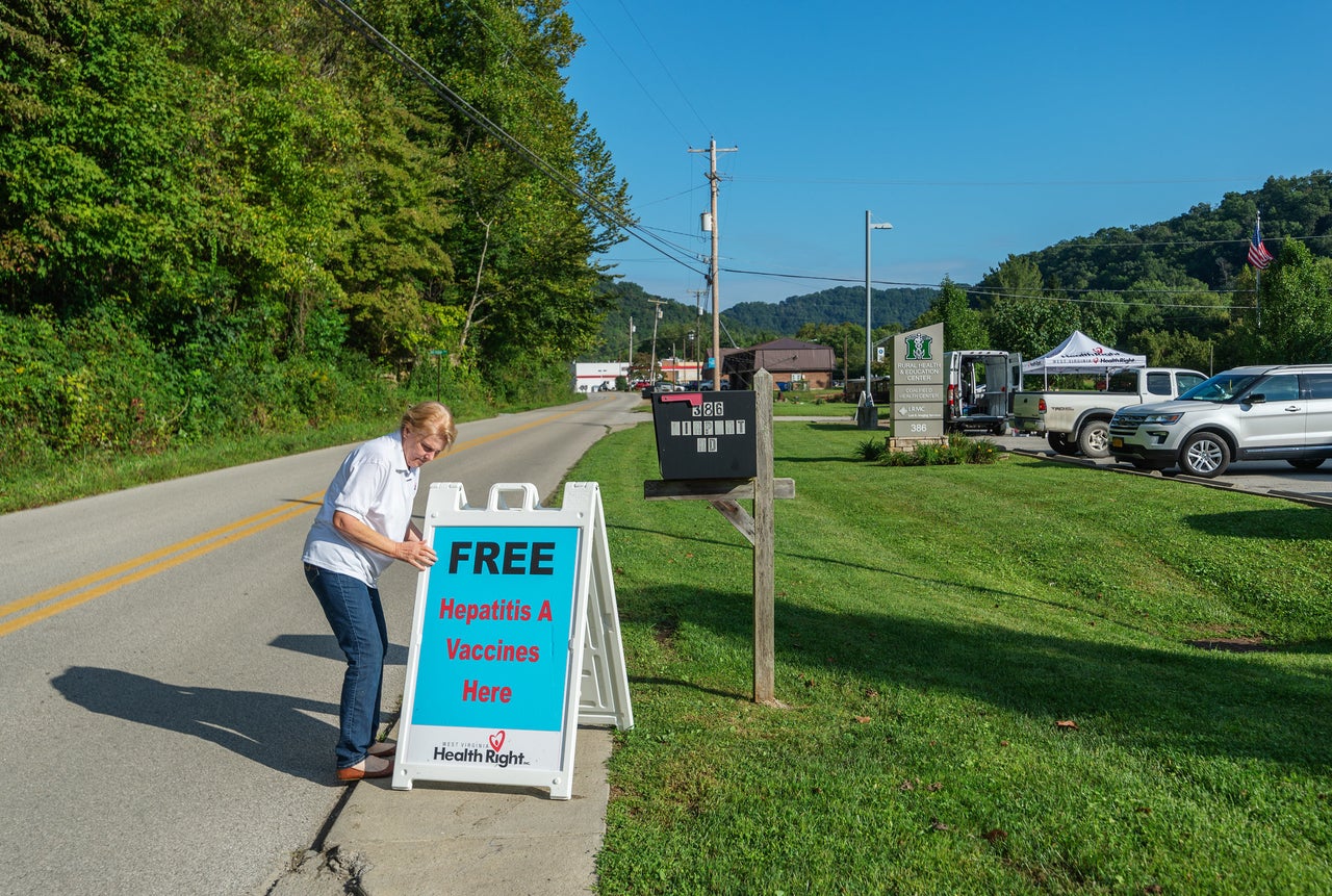 Brenda Parker, who works for West Virginia Health Right, sets up a sign advertising free hepatitis A vaccines as part of a mobile clinic that travels to rural areas around the state.