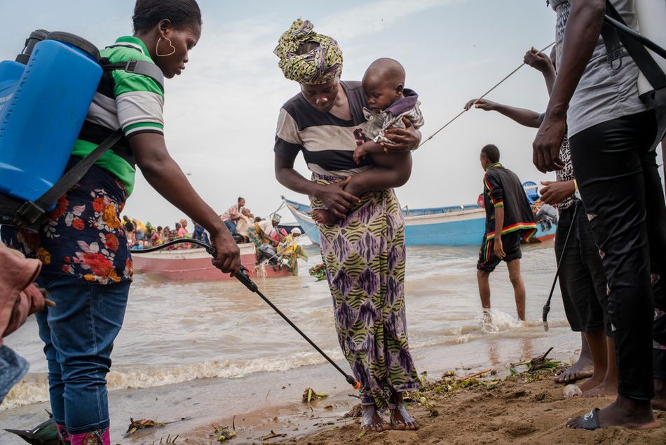 Εργαζόμενοι απολύμανσης ψεκάζουν τα χέρια και τα πόδια των Κονγκολέζων προσφύγων που φτάνουν στις όχθες της λίμνης Άλμπερτ, σε μια περιοχή όπου η χολέρα είναι ενδημική. Περίπου 60.000 πρόσφυγες έφτασαν στην Ουγκάντα με βάρκες από τον Δεκέμβριο του 2017 έως τον Μάρτιο του 2018, για να γλιτώσουν από τις συγκρούσεις στην επαρχία Ιτούρι της Λαϊκής Δημοκρατίας του Κονγκό. (Μάρτιος 2018)