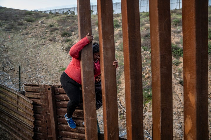 A migrant climbs the border fence before jumping into the U.S. to San Diego, Calif., from Tijuana, Mexico, on Dec. 27, 2018. 