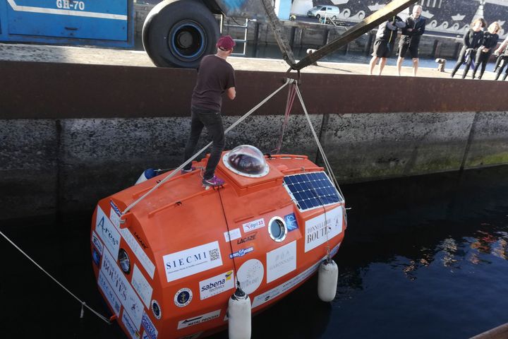 In this photograph taken Saturday Dec. 22, 2018, Frenchman Jean-Jacques Savin, 71-year-old, stands on top of his 10-foot-long, 7-foot-wide resin-coated plywood capsule, which will use ocean currents alone to propel him across the sea.