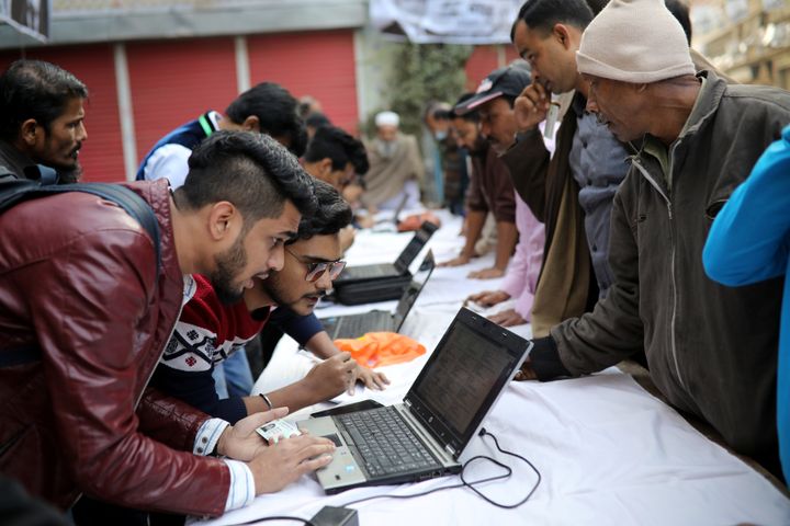 Political party agents help voters find their serial number and voting center during the general election in Dhaka, Bangladesh, December 30, 2018. 