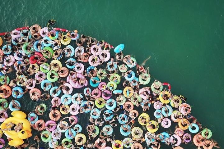 Άνθρωποι δροσίζονται με τα σοσίβιά τους σε πισίνα της επαρχίας Γιάνκγσου