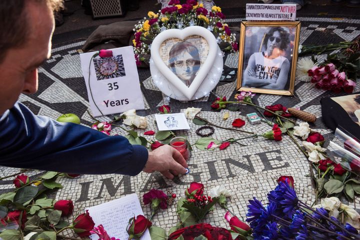 To mark the 35-year anniversary in 2015 of John Lennon's death, a fan of the late Beatle places a pin atop the 'Strawberry Fields' tile mosaic in Central Park that honors the musician.