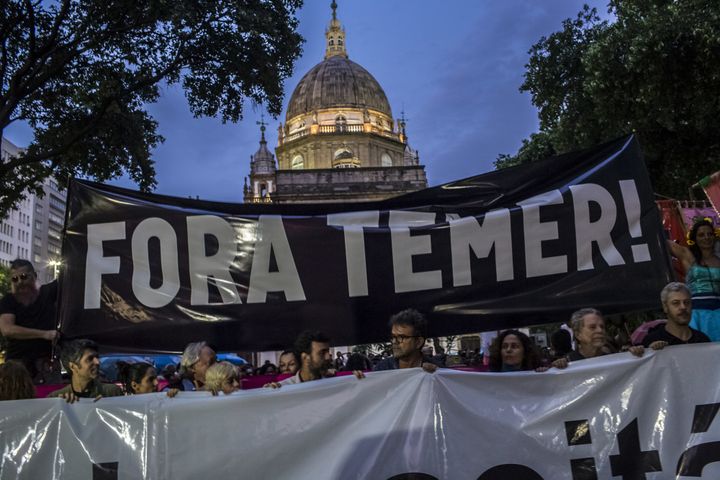 Protesters hold signs saying "Temer Out" in Portuguese to protest the unpopular centrist leader who took power after the impeachment of former leftist President Dilma Rousseff. Temer's links to corruption and pursuit of unpopular economic reforms sent his approval ratings into the single digits for most of his two years in office.