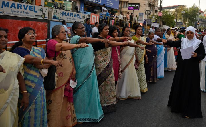 Women raise their hands to take a pledge to fight gender discrimination as they form part of the estimated 620 Kms-long "women's wall" in Thiruvananthapuram, in Kerala on Tuesday, Jan. 1, 2019. The wall was organized in the backdrop of conservative protestors blocking the entry of women of menstruating age at the Sabarimala temple--one of the world's largest Hindu pilgrimage sites--defying a recent ruling from the Apex court to let them enter.