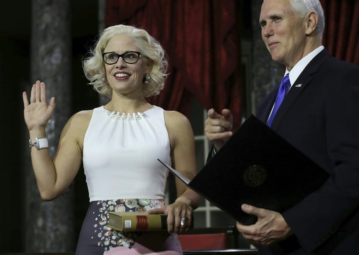 Sen. Kyrsten Sinema (D-Ariz.) holds a law book as she is sworn in by Vice President Mike Pence on Jan. 3 during the swearing-in re-enactments for recently elected senators in the Old Senate Chamber in Washington.