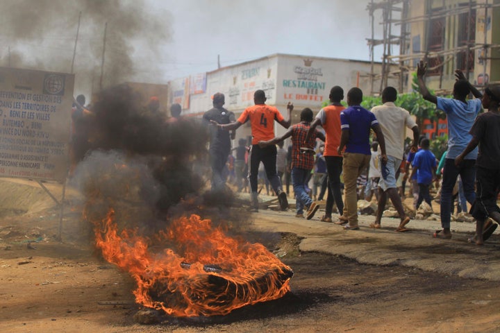 Protesters walk past a burning tire in Beni on Dec. 28, 2018, as they demonstrate against postponed voting in the Congolese election.