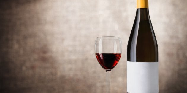 Red wine glass on wooden desk at