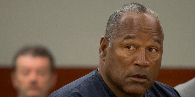 O.J. Simpson listens as his defense attorney, Ozzie Fumo (not shown), questions witness David Cook (also not shown) during an