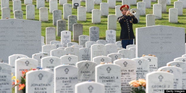 The official Bugler plays taps during the burial of US Army Specialist Anthony M. Lightfoot, of Riverdale, Ga, on August 4, 2009, inside Arlington National Cemetery in Arlington, Virginia. Lightfoot died last month in the Wardak province, Afghanistan, when an improvised explosive device detonated near his vehicle. As of today, there are 463 casualties of Operation Iraqi Freedom interred, inurned or memorialized at Arlington National Cemetery. There are 556 service members from both Operations Iraqi Freedom and Enduring Freedom interred, inurned or memorialized at the cemetery. AFP Photo/Paul J. Richards (Photo credit should read PAUL J. RICHARDS/AFP/Getty Images)