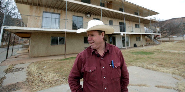 In this Tuesday, Dec. 16, 2014, photo Isaac Wyler, a former member of The Fundamentalist Church of Jesus Christ of Latter-Day Saints, (FLDS) who now works with Utah state officials to handle evictions, stands in front of an evicted polygamous property, in Hildale, Utah. A Utah judge has finally appointed a board of trustees to sort out the redistribution of more than 700 homes in the polygamous community on the Utah-Arizona border where Warren Jeffs' sect is based. (AP Photo/Rick Bowmer)