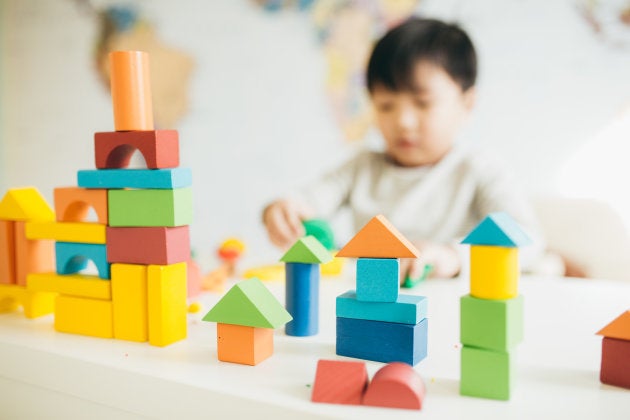 Focus on wooden blocks and child on background