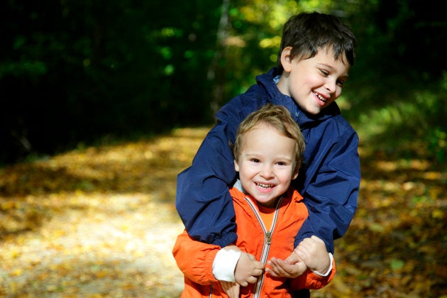 Two young brothers with special need engage in playful behavior. Both boys have received diagnoses of PDD-NOS. The older brother has autism and ADHD.