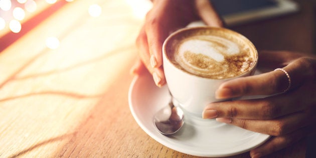 Closeup shot of an unrecognizable woman having a cup of coffee at a cafe