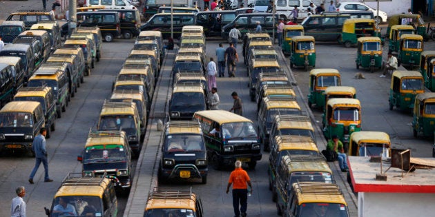 In this Monday, March 24, 2014 photo, traditional black-and-yellow licensed cabs stand parked waiting for customers at a railway station in New Delhi, India. Most licensed taxis are banned from having air conditioning under an archaic municipal rule, leaving passengers suffering with rolled-down windows in suffocating heat and noxious pollution. Taxi-hailing smartphone app Uber is making a big push into Asia with the company starting operations in 18 cities in Asia and the South Pacific including Seoul, Shanghai, Bangkok, Hong Kong and five Indian cities in the last year. (AP Photo/Saurabh Das)