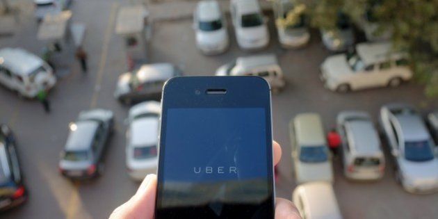 The Uber smartphone app, used to book taxis using its service, is pictured over a parking lot in the Indian capital New Delhi on December 7, 2014. An Uber taxi driver allegedly raped a 25-year-old passenger in the Indian capital before threatening to kill her, police said December 7, in a blow to the company's safety-conscious image. AFP PHOTO/TENGKU BAHAR (Photo credit should read TENGKU BAHAR/AFP/Getty Images)
