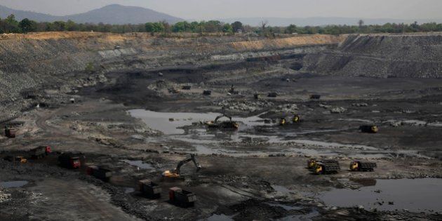 This April 15, 2014 photo, shows mining in progress at an open coat pit that belongs to Jindal Steel & Power Ltd. at Sarasmal village near the industrial city of Raigarh, in Chhattisgarh state, India. Each morning the ground shakes violently beneath Sarasmal and the neighboring village of Gare as mining crews blast the open coal pit with dynamite, sending clouds of coal dust into the air. (AP Photo/Rafiq Maqbool)