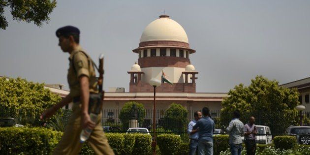 A security personel walks in front of the Indian Supreme court in New Delhi on August 27, 2014. India's top court said lawmakers with criminal backgrounds should not serve in government, with 13 ministers facing charges for attempted murder, rioting and other offences. The ruling is likely to put pressure on right-wing Prime Minister Narendra Modi, who swept to power this year pledging clean governance. AFP PHOTO/ SAJJAD HUSSAIN (Photo credit should read SAJJAD HUSSAIN/AFP/Getty Images)