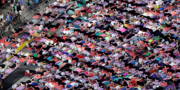 Thousands of New Yorkers are marking the first day of summer by practicing yoga in Times Square, during the 12th annual Solstice in Times Square, sponsored by the Times Square Alliance and Athleta, Gap Inc.'s exercise-wear brand, Saturday, June 21, 2014. (AP Photo/Richard Drew)