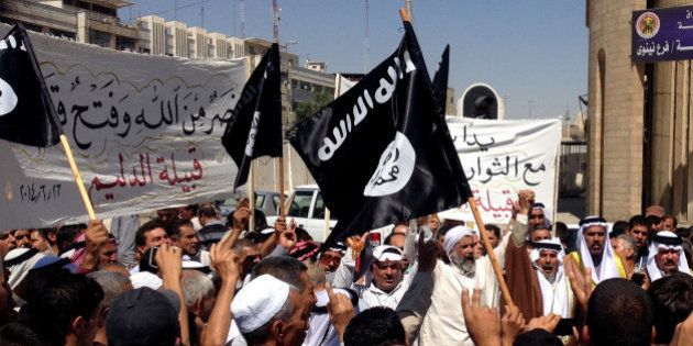 Demonstrators chant pro-al-Qaida-inspired Islamic State of Iraq and the Levant (ISIL) as they wave al-Qaida flags in front of the provincial government headquarters in Mosul, 225 miles (360 kilometers) northwest of Baghdad, Iraq, Monday, June 16, 2014. Sunni militants captured a key northern Iraqi town along the highway to Syria early on Monday, compounding the woes of Iraq's Shiite-led government a week after it lost a vast swath of territory to the insurgents in the country's north. (AP Photo)
