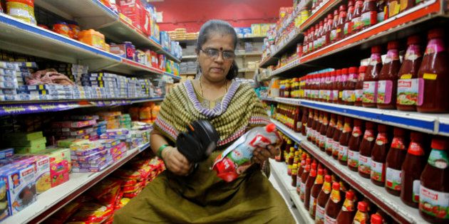 An Indian saleswoman puts a price tag on a product at a retail shop in Mumbai, India, Wednesday, Dec. 5, 2012. India's ruling Congress Party-led coalition government on Wednesday won a crucial vote in favor of its decision to open up the country's huge retail sector to foreign big-box companies like Wal-Mart, a move that its opponents said will crush small shop owners and farmers. (AP Photo/Rajanish Kakade)